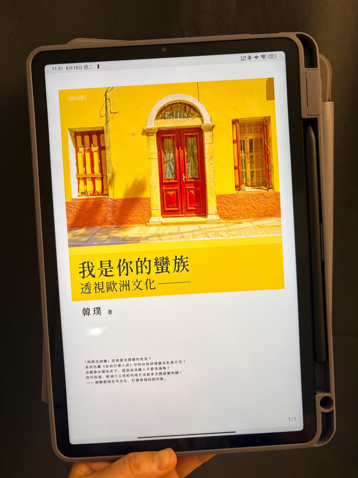 手裡拿著平板，螢幕上是《我是你的蠻族——透視歐洲文化》的電子書封面
